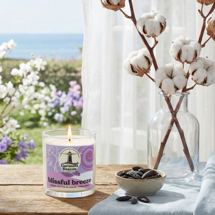Candle labeled 'blissful breeze' on a table with a scenic background