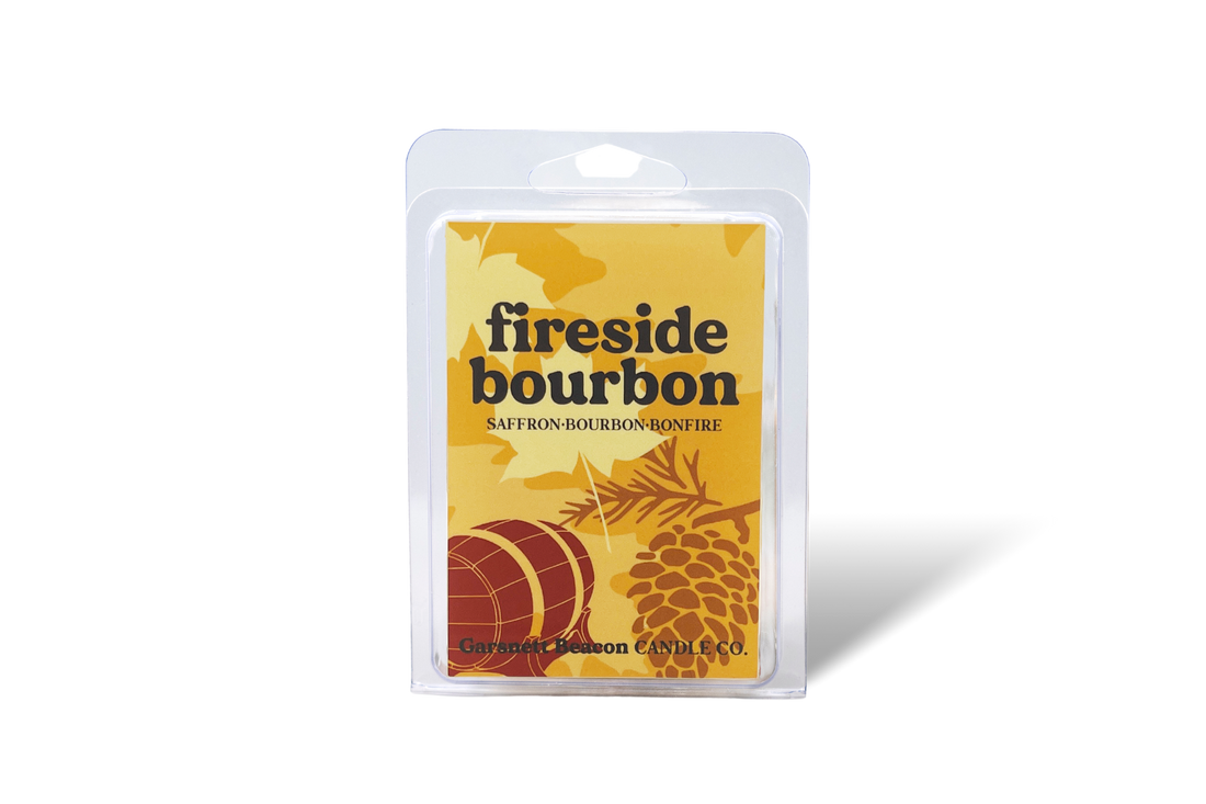 Fireside bourbon wax melt packaging with saffron, cinnamon sticks, and wood on a beige background